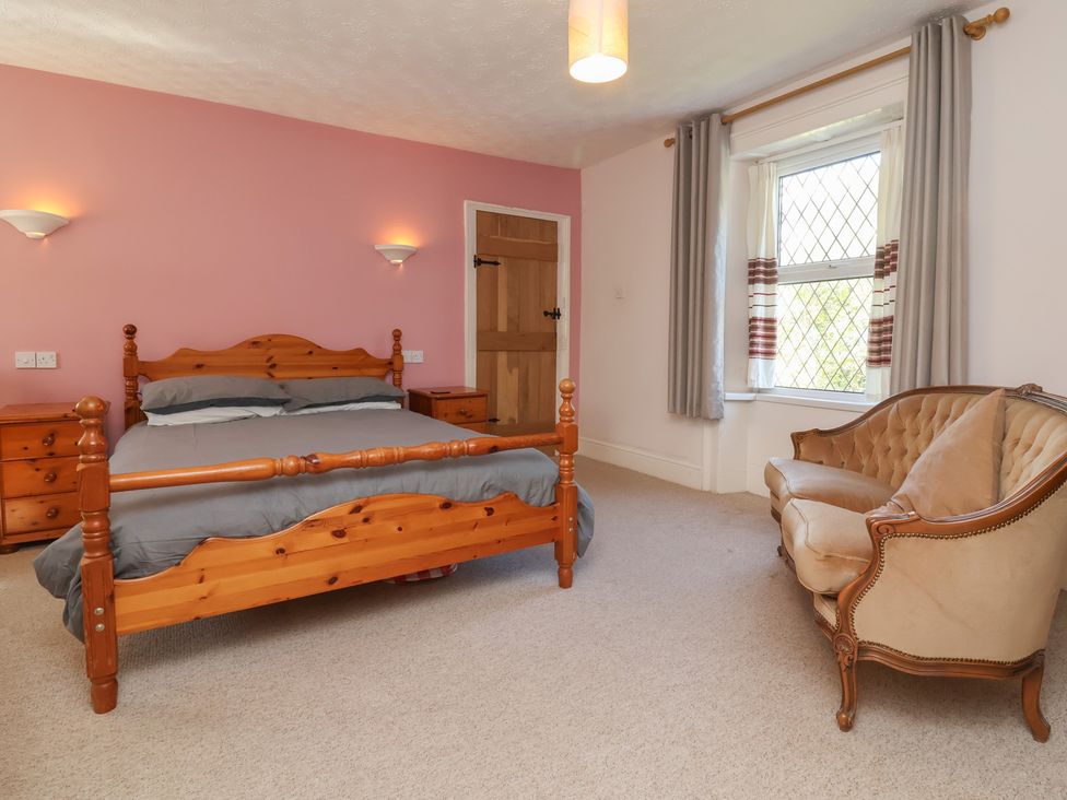 A bedroom with a bed and drawer unit at Honey Cottage Ilfracombe