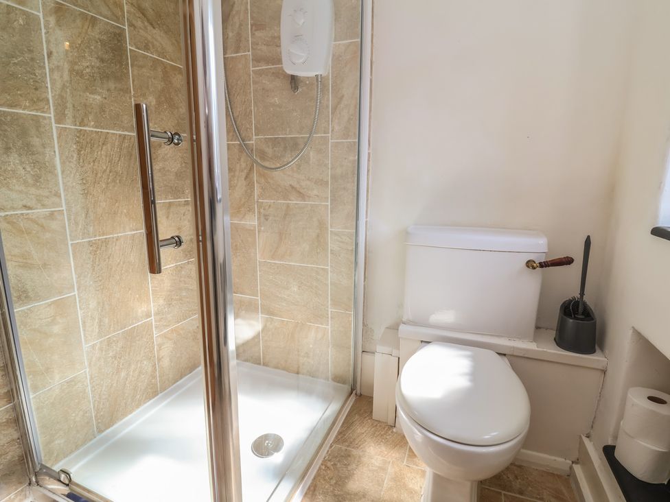 A bathroom with a shower and a toilet at Honey Cottage Ilfracombe