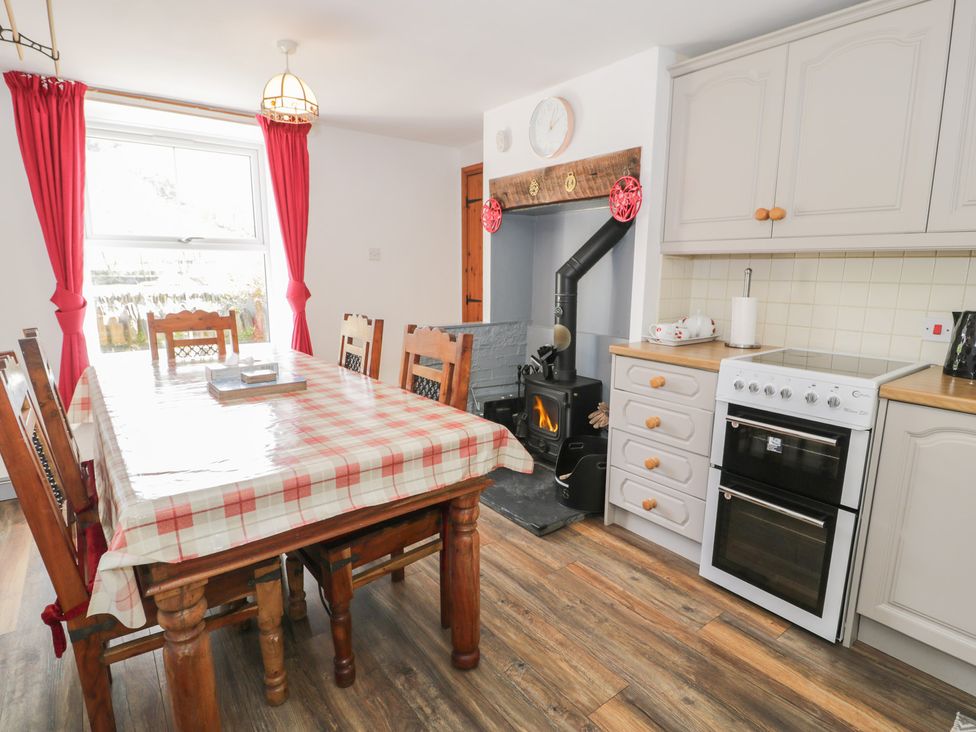 A kitchen with a dining table and stove at Ysgoldy in Dolwyddelan