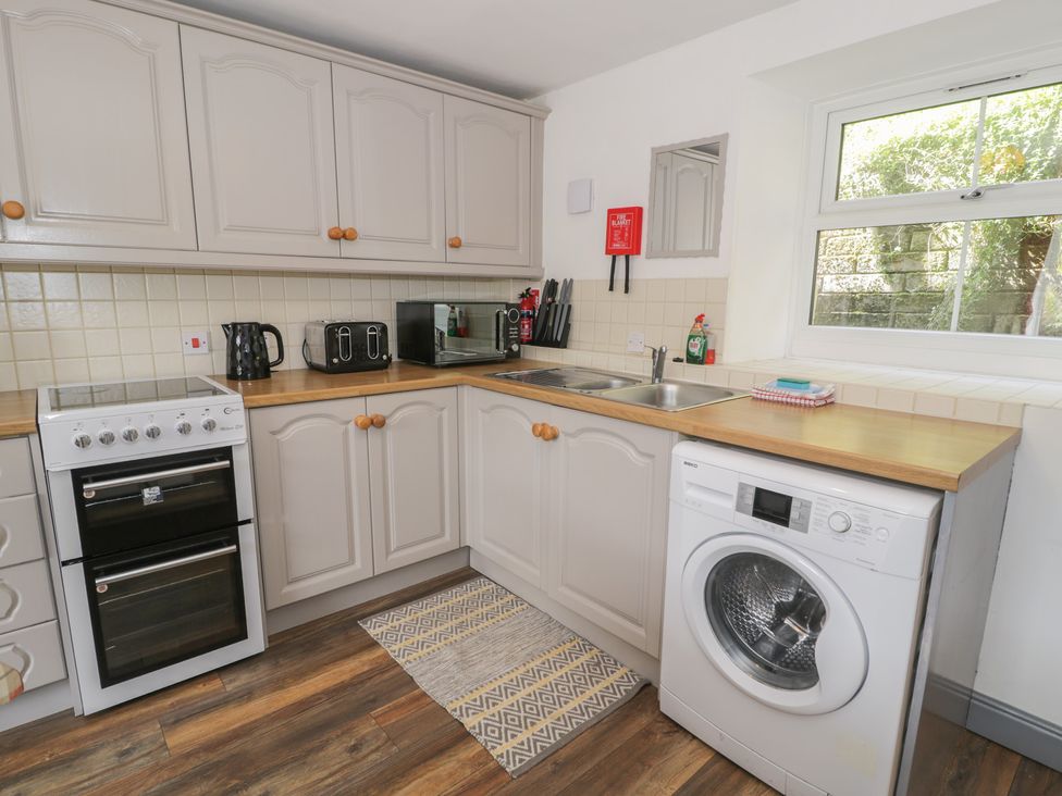 A kitchen with cabinets, oven, sink, and appliances at Ysgoldy in Dolwyddelan