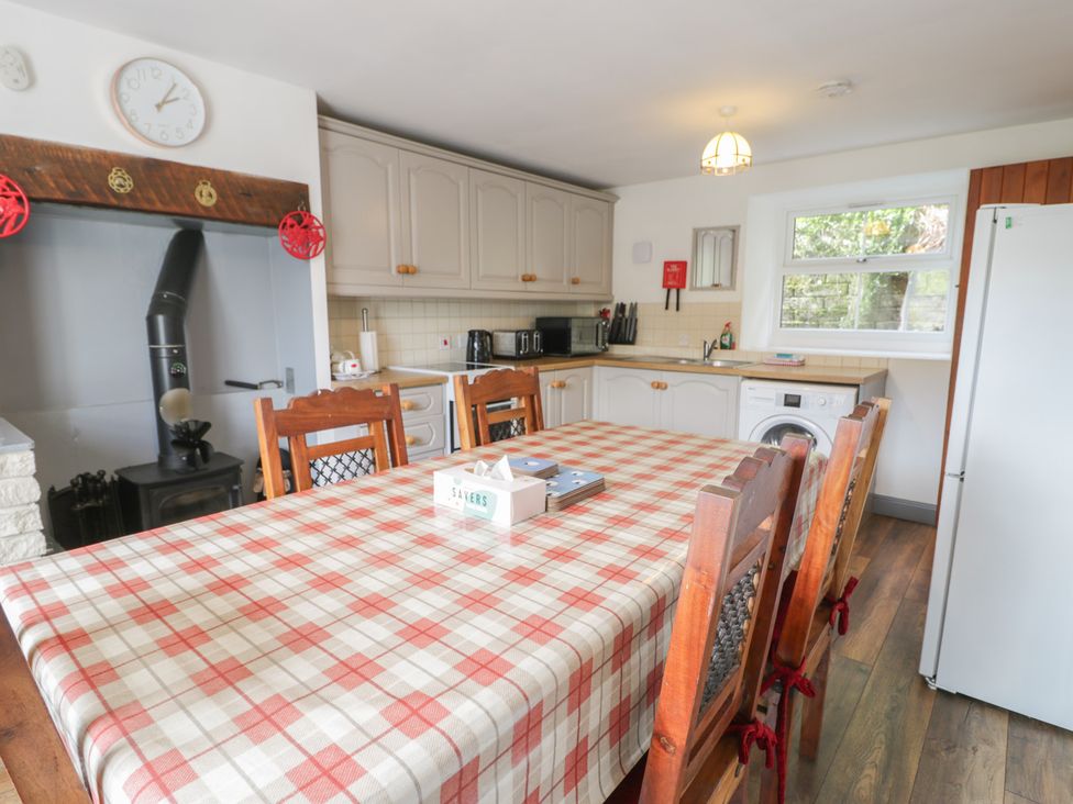 A kitchen with a dining table and appliances at Ysgoldy in Dolwyddelan