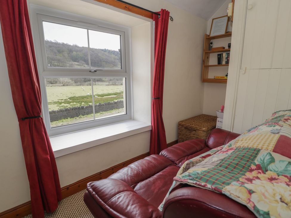 A bedroom with a window and sofa at Ysgoldy in Dolwyddelan