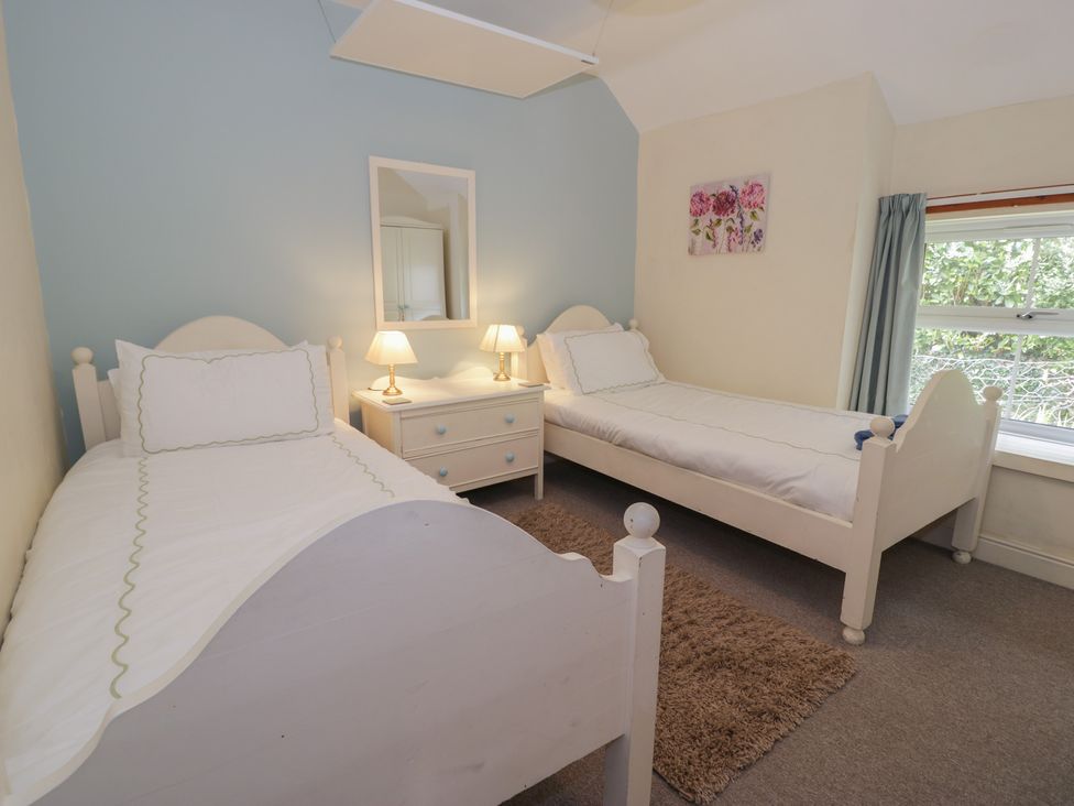 A bedroom with two single beds and a nightstand at Ysgoldy in Dolwyddelan