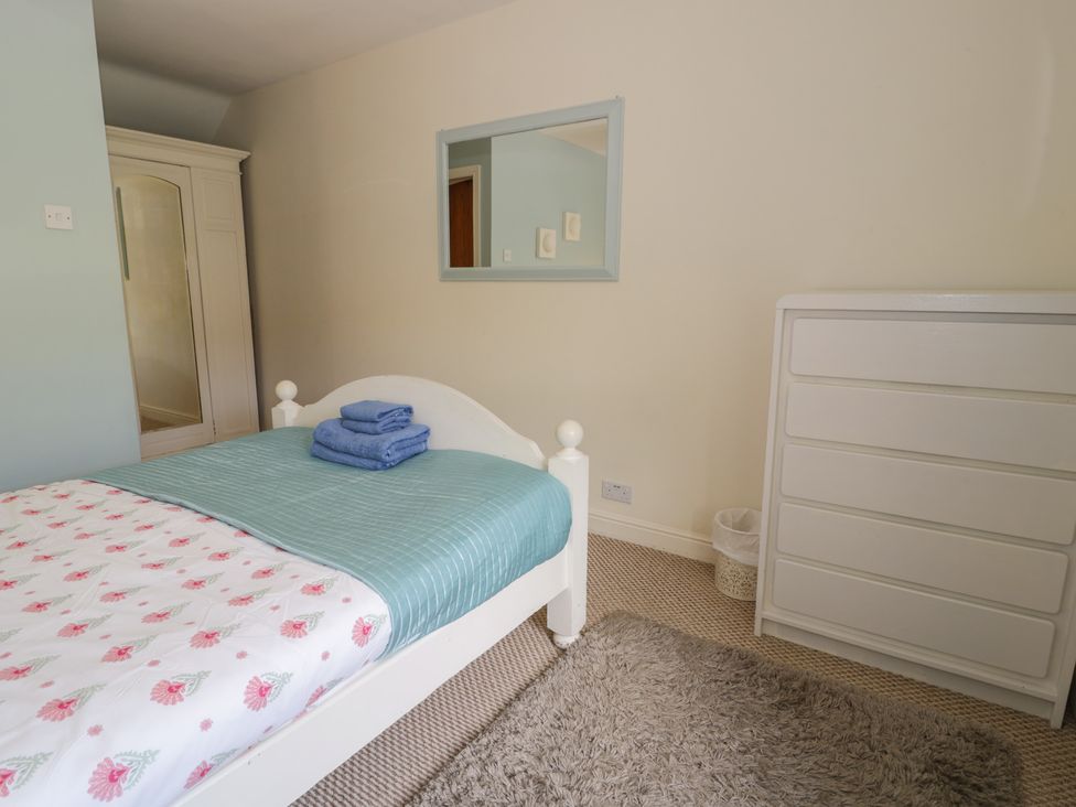 A bedroom with a bed and towels on it at Ysgoldy in Dolwyddelan