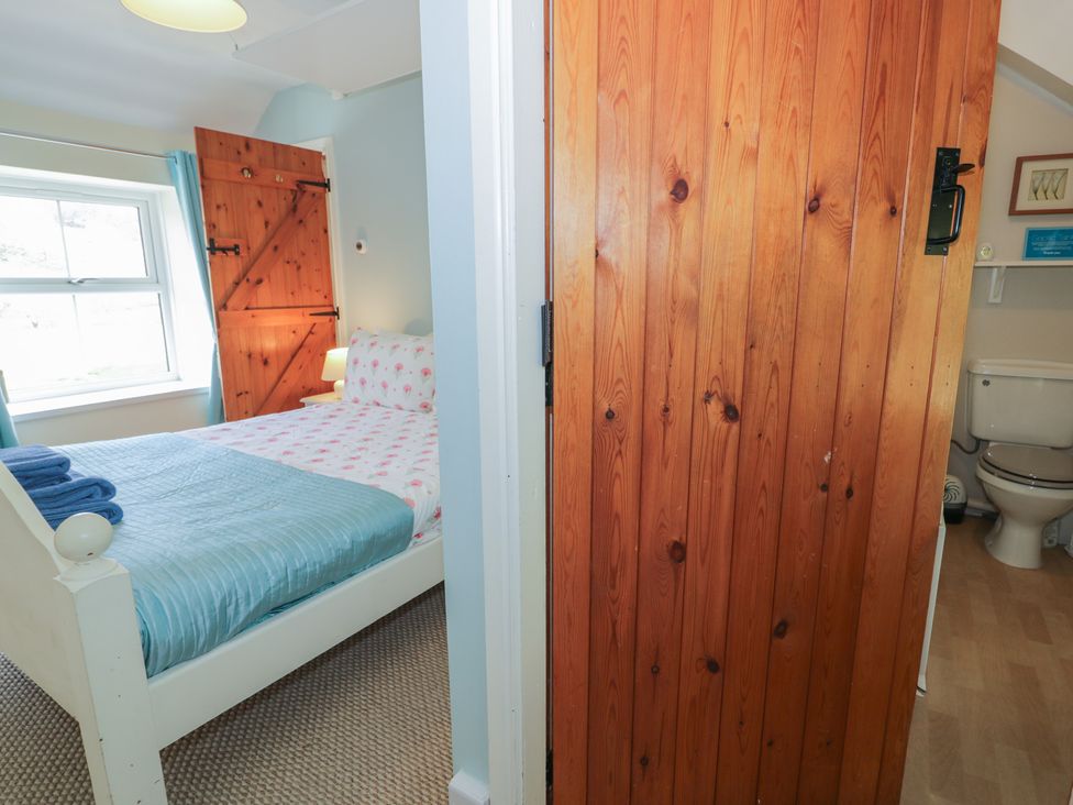 A bedroom with a bed and a door to the bathroom at Ysgoldy in Dolwyddelan