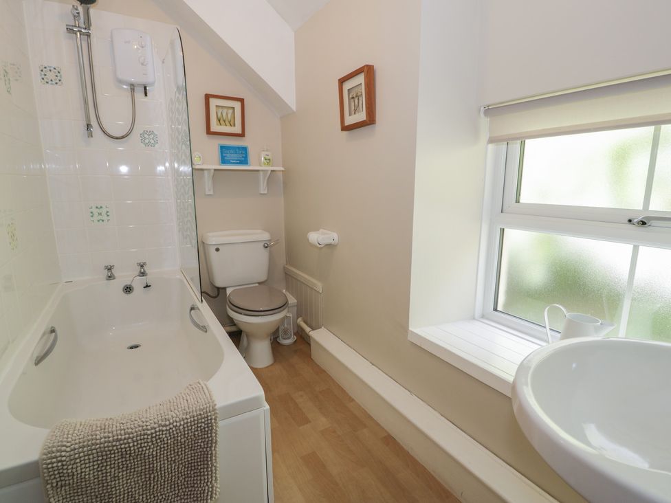 A bathroom with a bathtub, toilet, and sink at Ysgoldy in Dolwyddelan