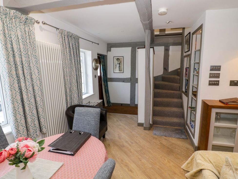 A living room with staircase and dining table at Middle Cottage Ludlow