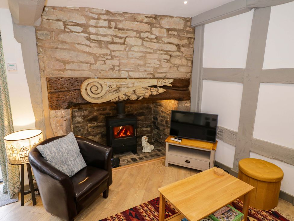 A living room with a fireplace and television at Middle Cottage in Ludlow