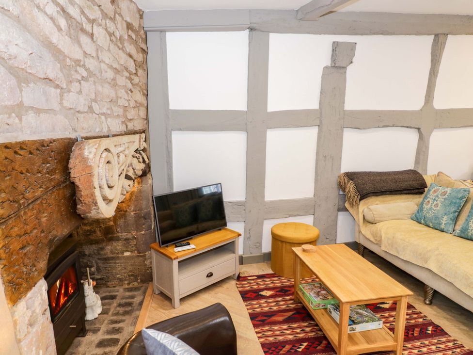 A living room with a fireplace and a tv at Middle Cottage in Ludlow