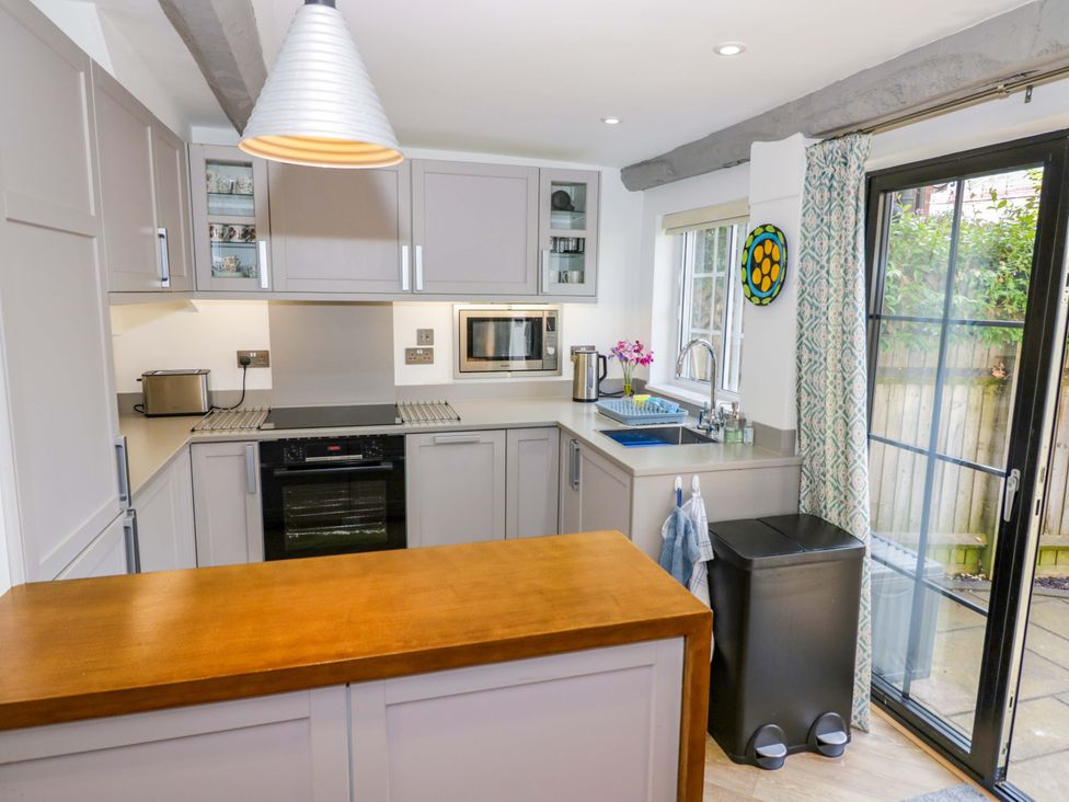 A kitchen with appliances and a sliding door at Middle Cottage in Ludlow