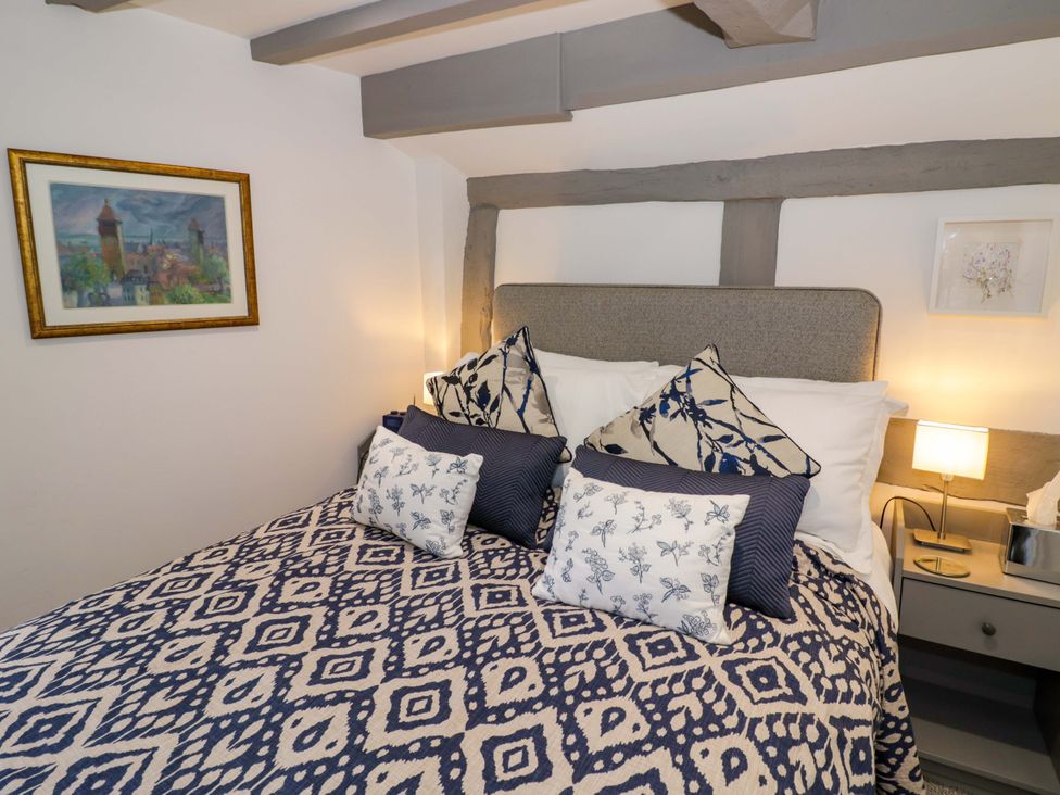 A bedroom with a bed and bedside table at Middle Cottage in Ludlow