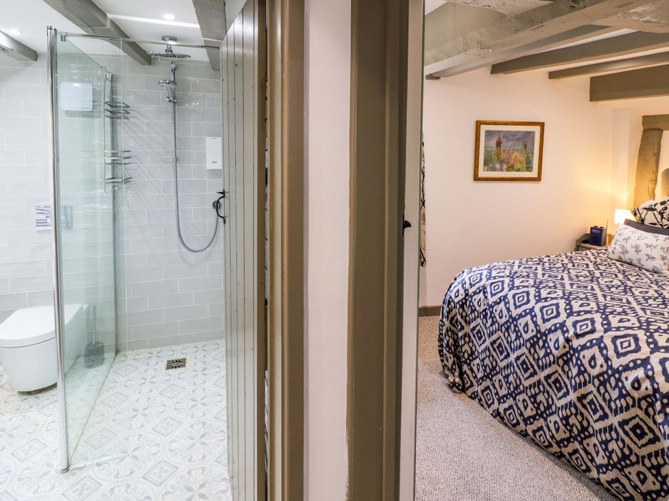 A bathroom with a shower and a bedroom with a bed at Middle Cottage in Ludlow