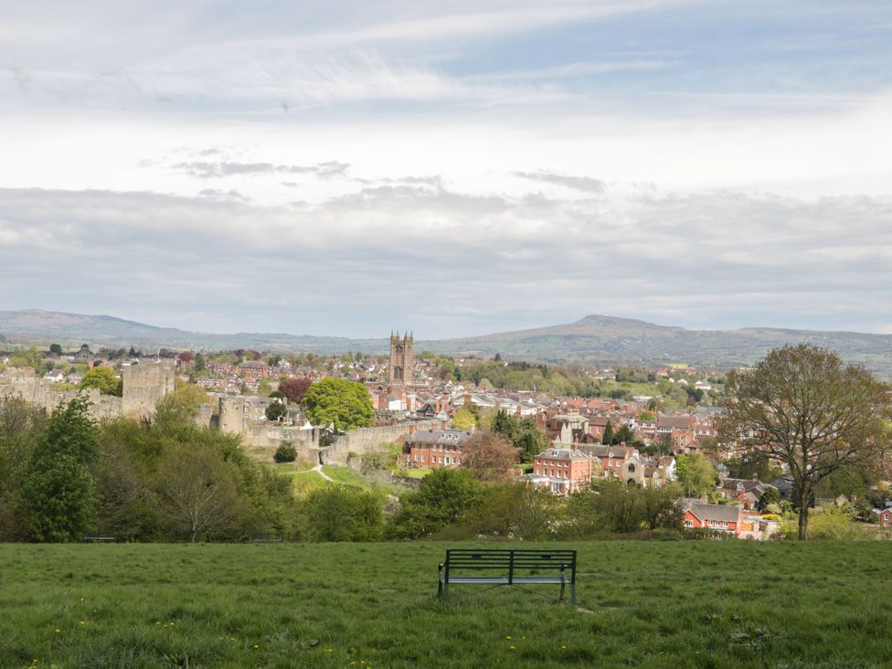 A cityscape view from a park with a bench overlooking the town at Middle Cottage in Ludlow