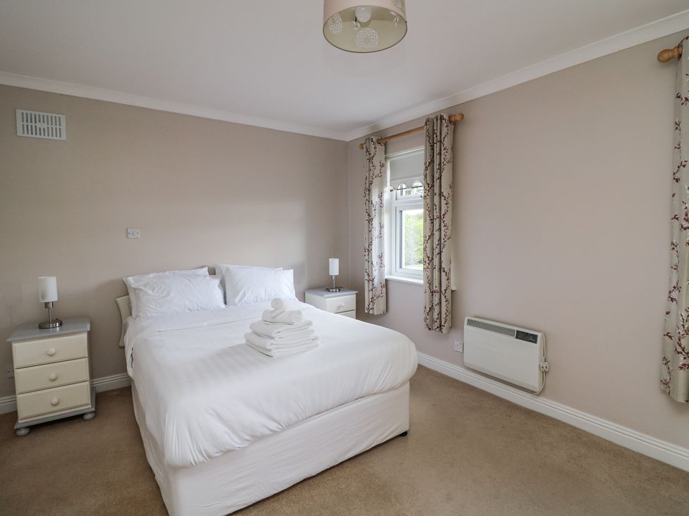 A bedroom with a bed and side tables at Dunbrody Dreams