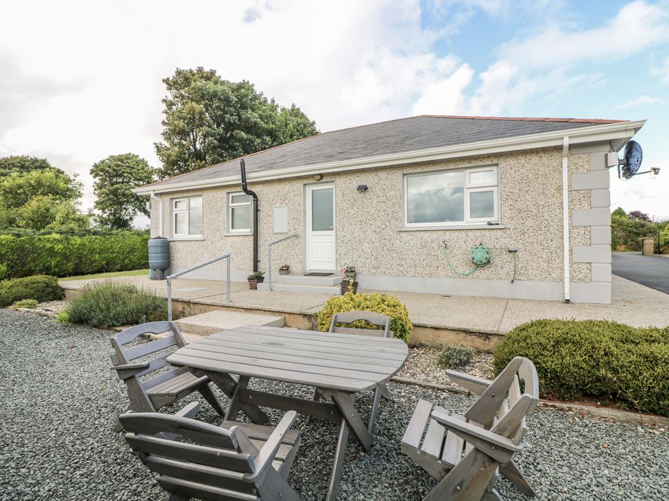 A house with a table and chairs in the garden at Dunbrody Dreams