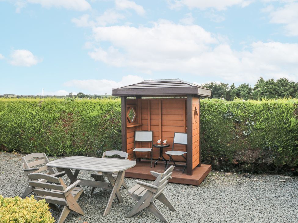 A garden shed with seating and a table at Dunbrody Dreams
