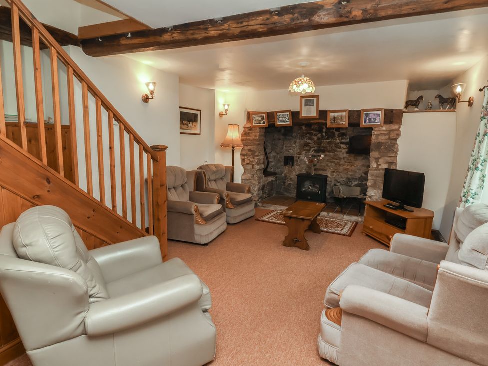 A living room with a fireplace and seating at Denhill Cottage