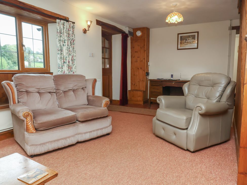 A living room with a sofa and armchair at Denhill Cottage