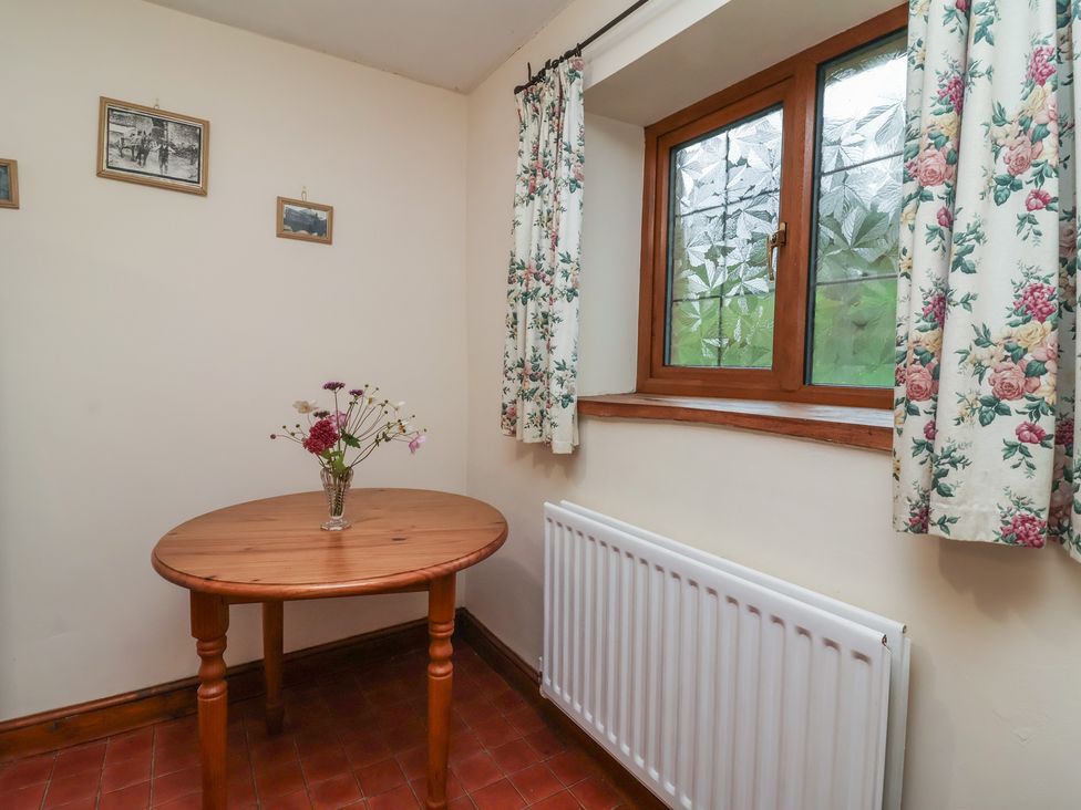 A dining room with a table and window at Denhill Cottage 