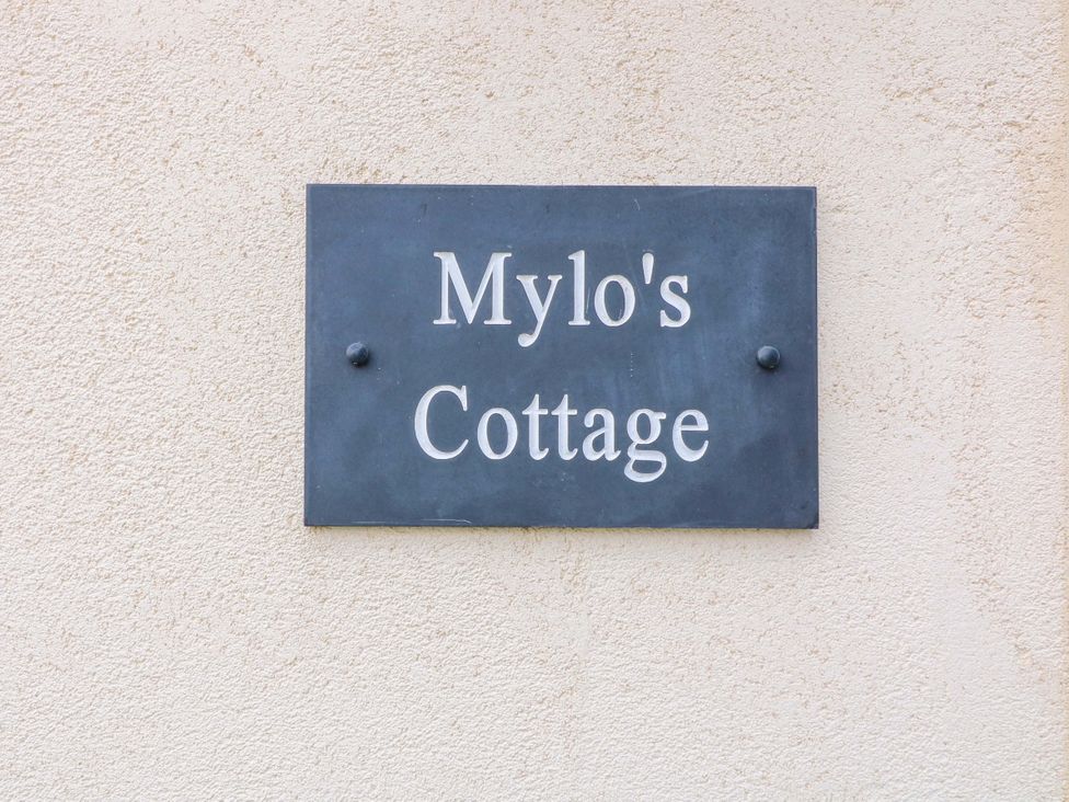 A sign with the text Mylo's Cottage on a wall in Langrick near Boston