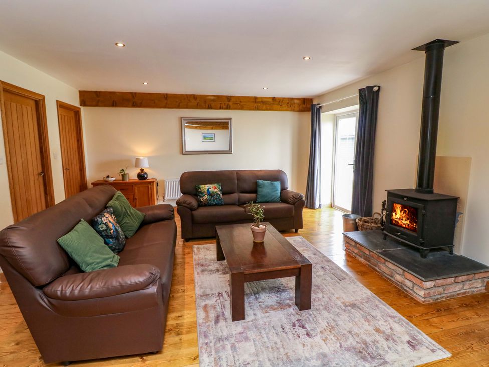 A living room with a stove and coffee table at Mylo's Cottage in Langrick near Boston