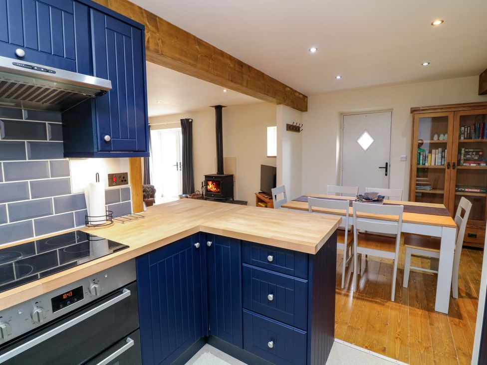 A kitchen with a counter, stove, and dining area at Mylo's Cottage in Langrick near Boston