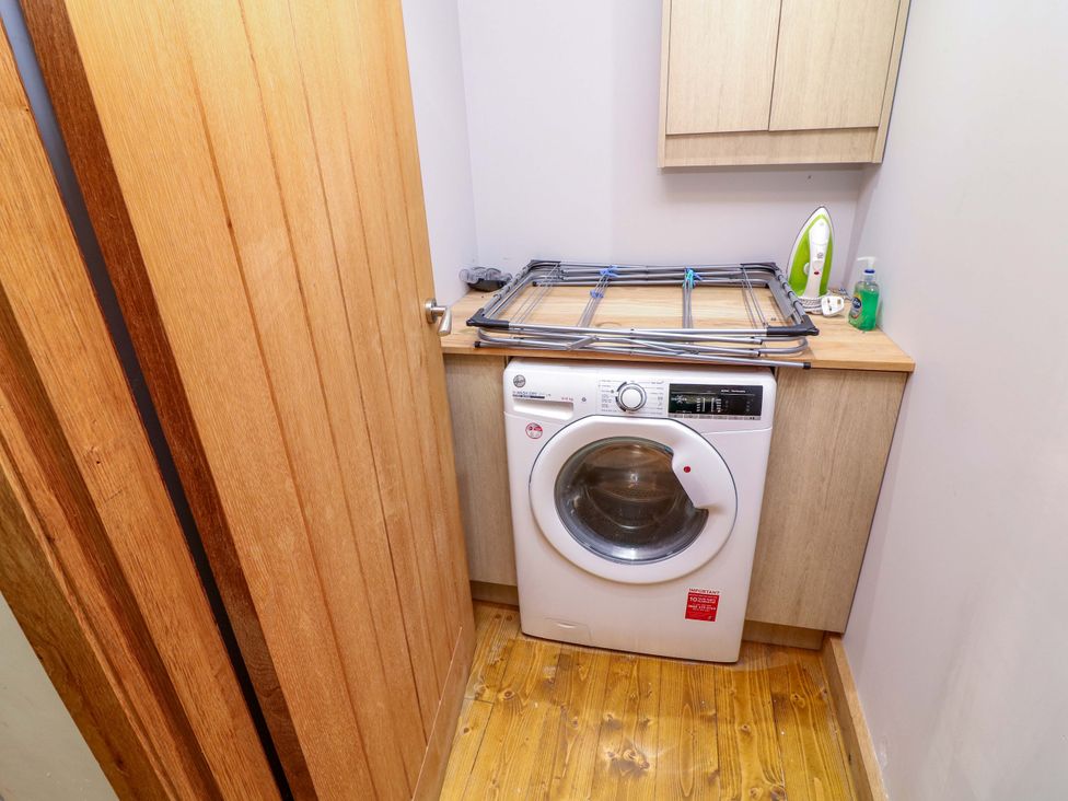 A washing machine and shelf in a laundry room at Mylo's Cottage Langrick near Boston