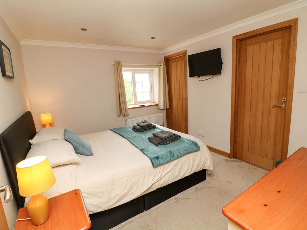 A bedroom with a bed and television at Mylo's Cottage in Langrick near Boston