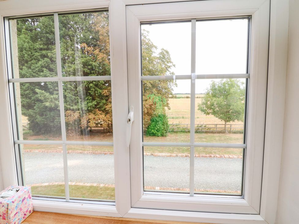 A window view showing trees and a road at Mylo's Cottage in Langrick near Boston