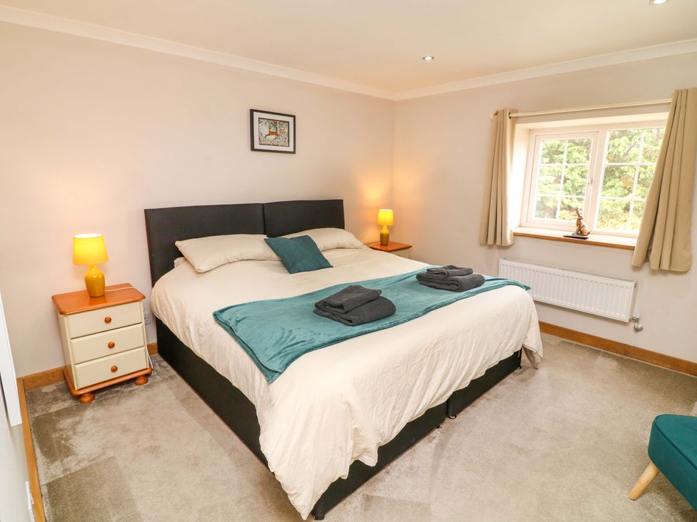 A bedroom with a bed and nightstand at Mylo's Cottage in Langrick near Boston