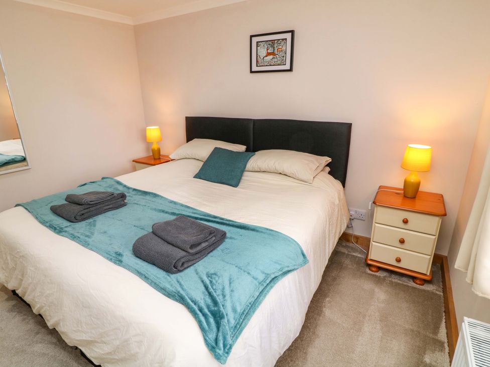 A bedroom with a bed and bedside table at Mylo's Cottage in Langrick near Boston