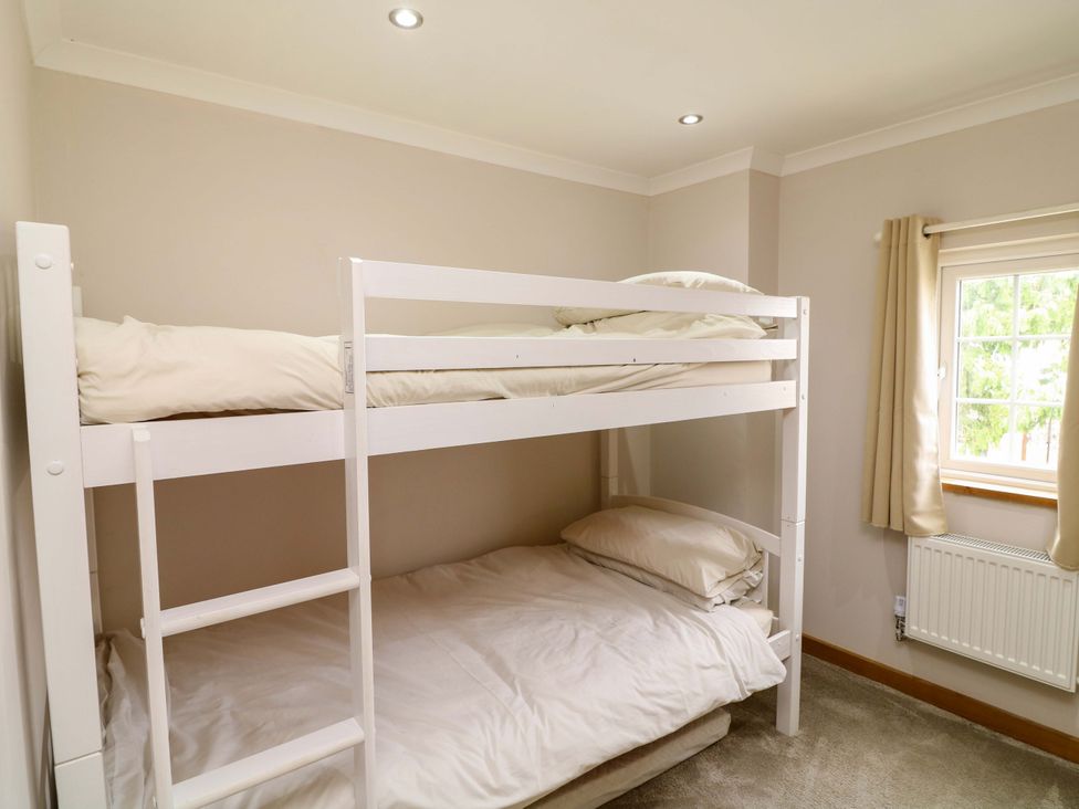A bunk bed with bed linens in a bedroom at Mylo's Cottage in Langrick near Boston