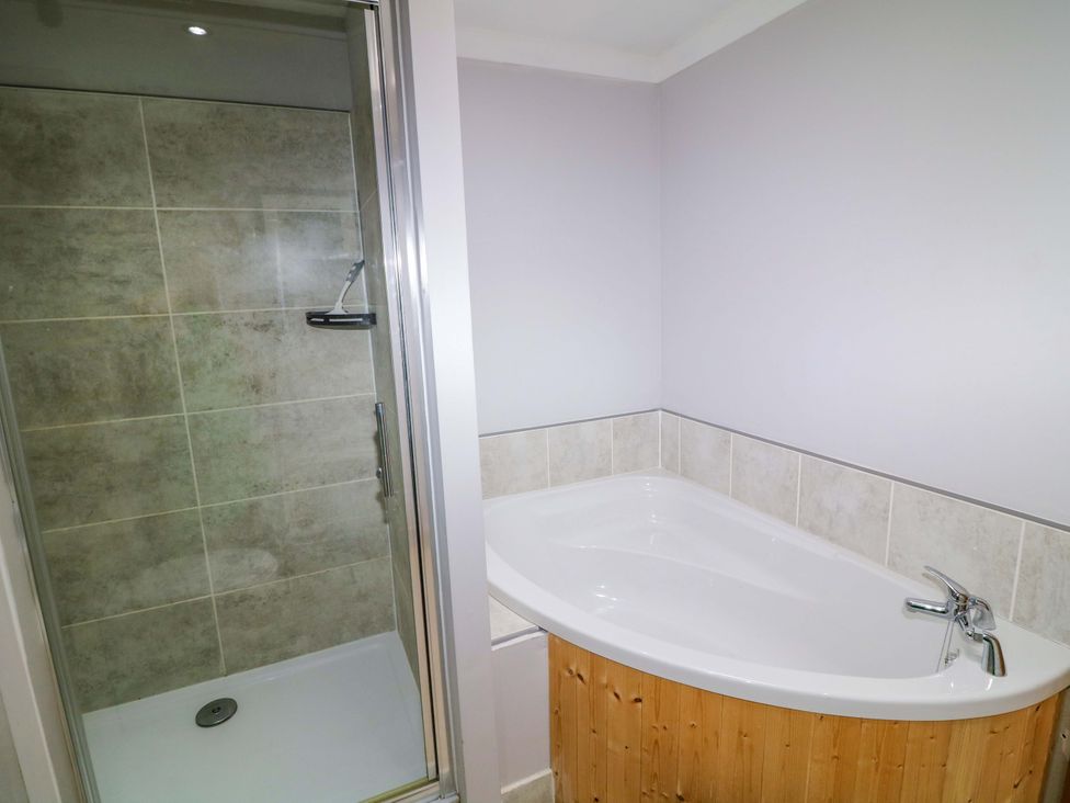 A bathroom with a shower and a bathtub at Mylo's Cottage in Langrick near Boston