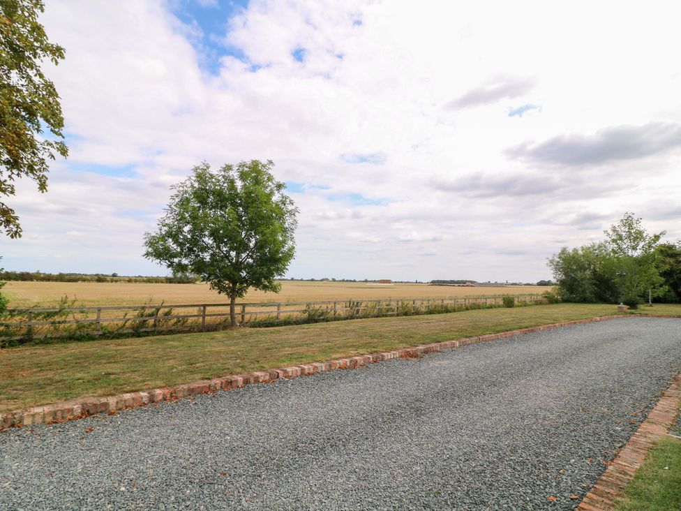An outdoor view featuring a gravel driveway and tree at Mylo's Cottage in Langrick near Boston