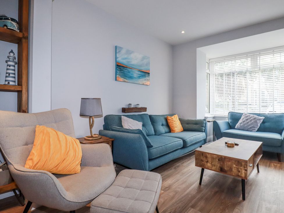 A living room with a sofa and armchair at Sea Boots in Newquay