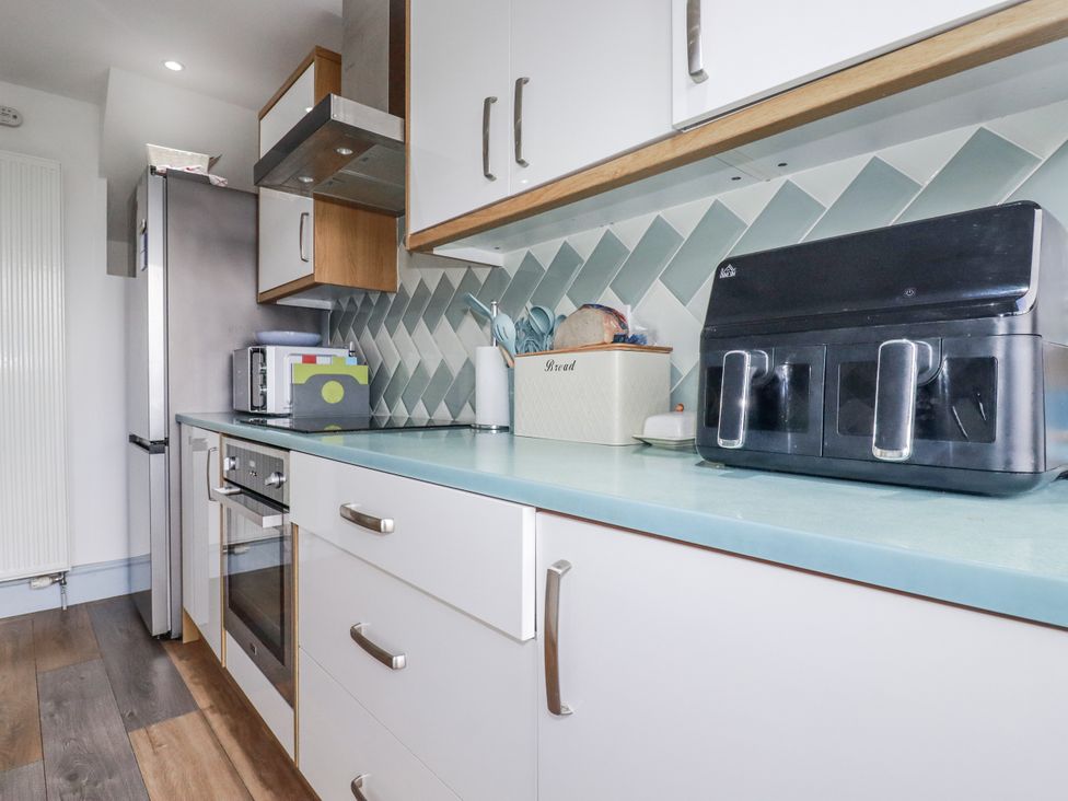 A kitchen with a fridge, oven, toaster, and bread box at Sea Boots in Newquay