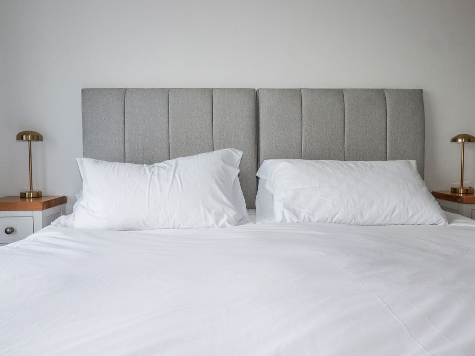 A bedroom with a bed, pillows and lamps at Sea Boots in Newquay