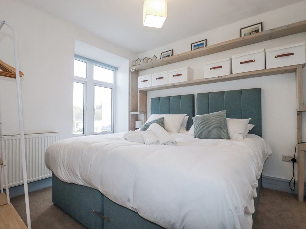 A bedroom with a bed and storage boxes at Sea Boots in Newquay