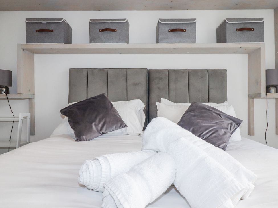 A bedroom with a bed and decorative pillows at Sea Boots in Newquay