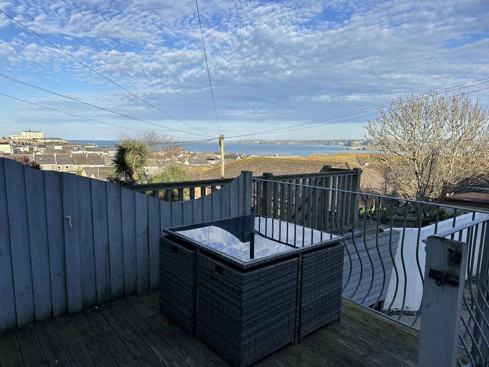 A deck with a table and view of the sea at Sea Boots in Newquay