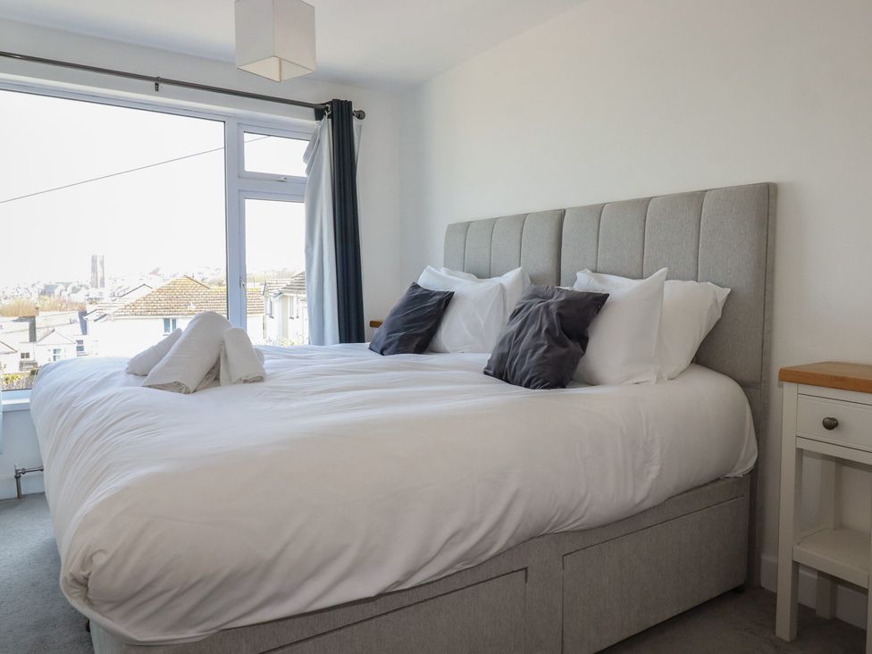 A bedroom with a bed and a nightstand at Sea Boots in Newquay