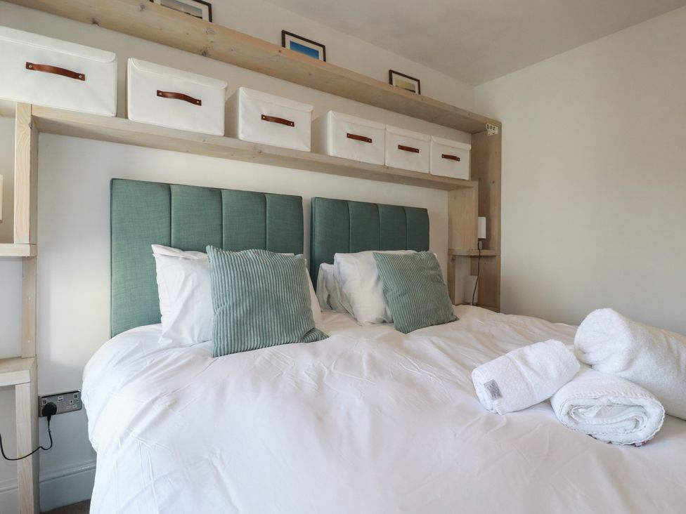 A bedroom with a bed and shelves at Sea Boots in Newquay