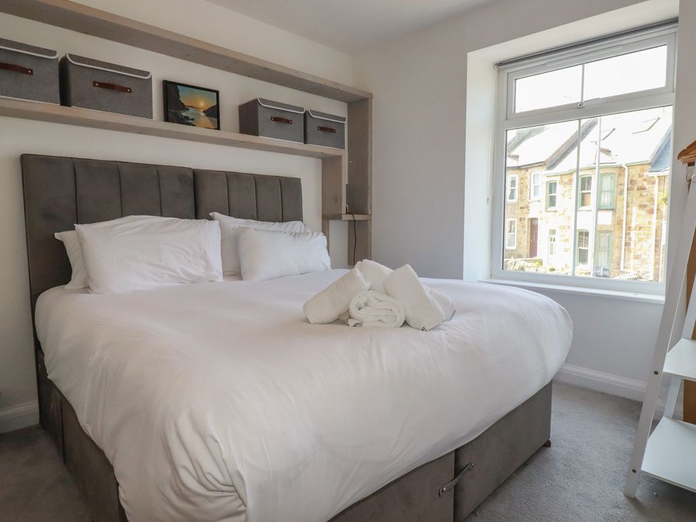 A bedroom with a bed and storage shelves at Sea Boots in Newquay