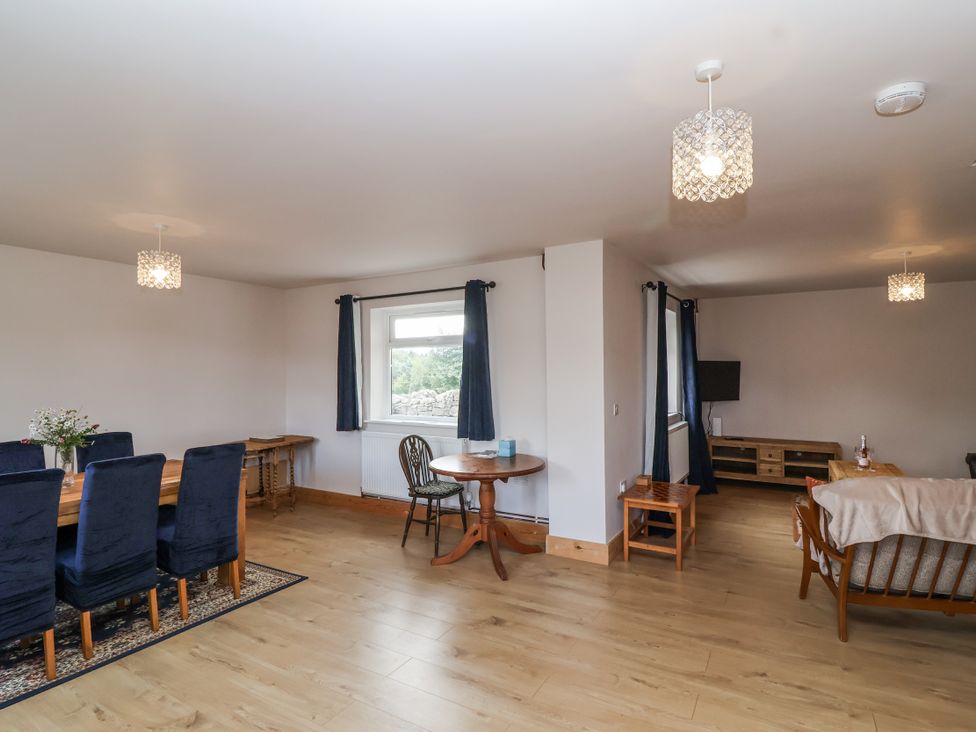 A living room with a dining area and sofa at The Miners Cottage in Wells