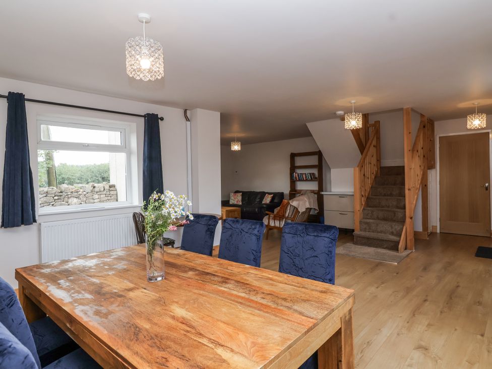 A dining room with a wooden table and chairs at The Miners Cottage in Wells