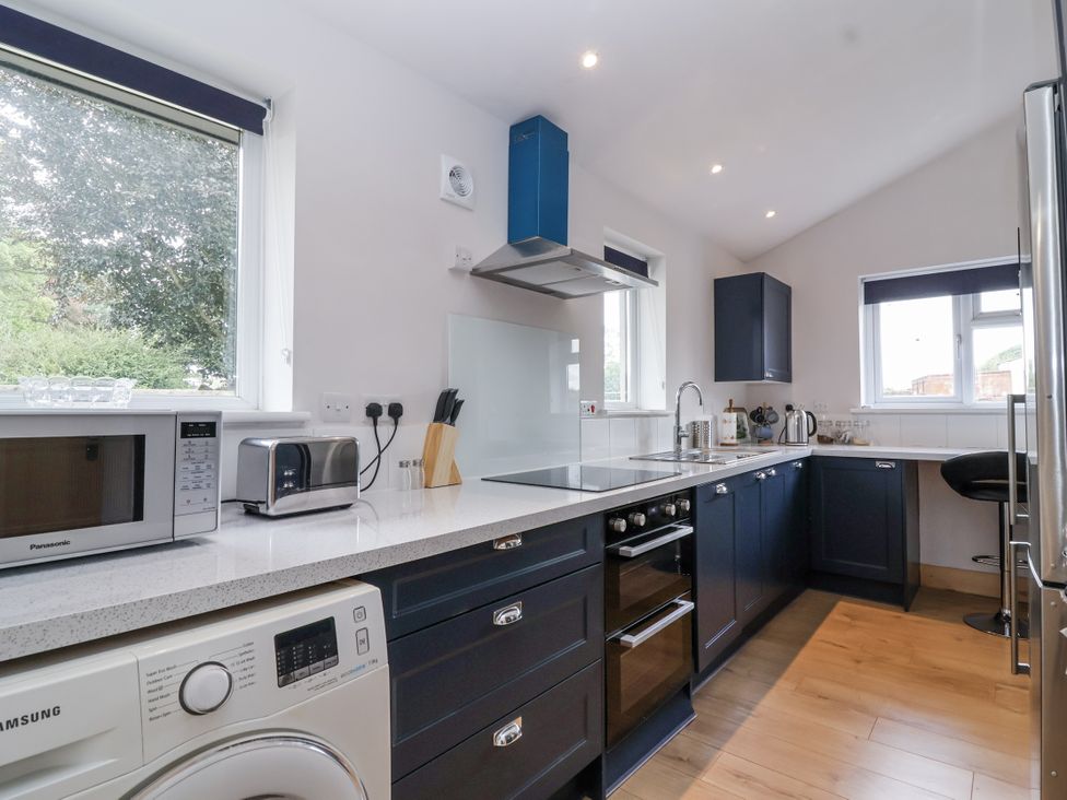 A kitchen with appliances and cabinets at The Miners Cottage in Wells