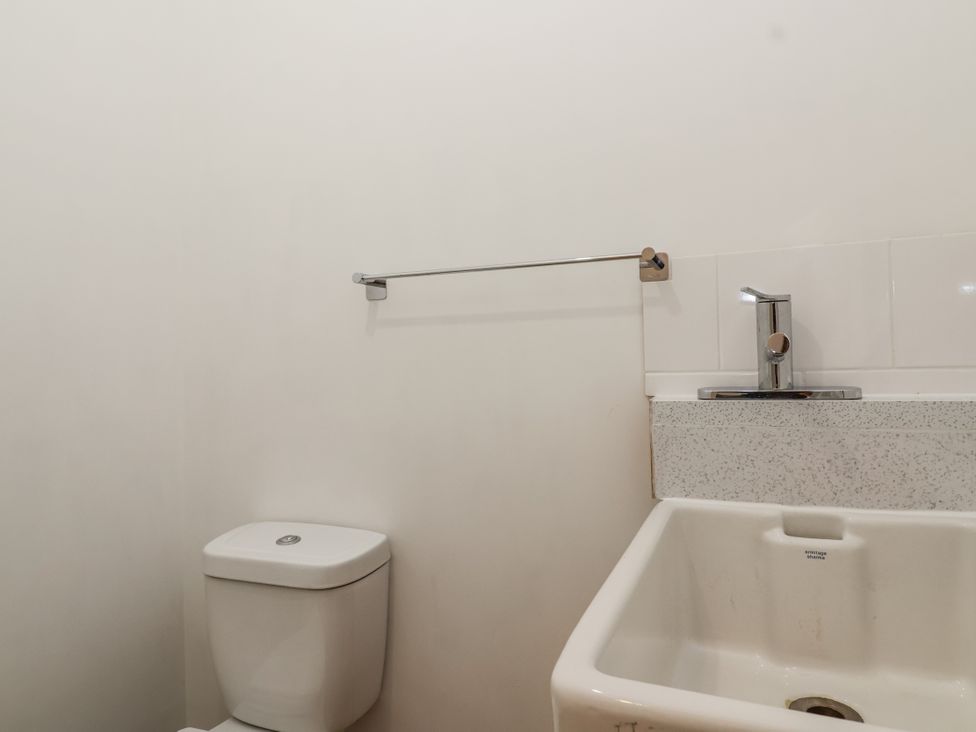 A bathroom featuring a toilet and a sink at The Miners Cottage in Wells