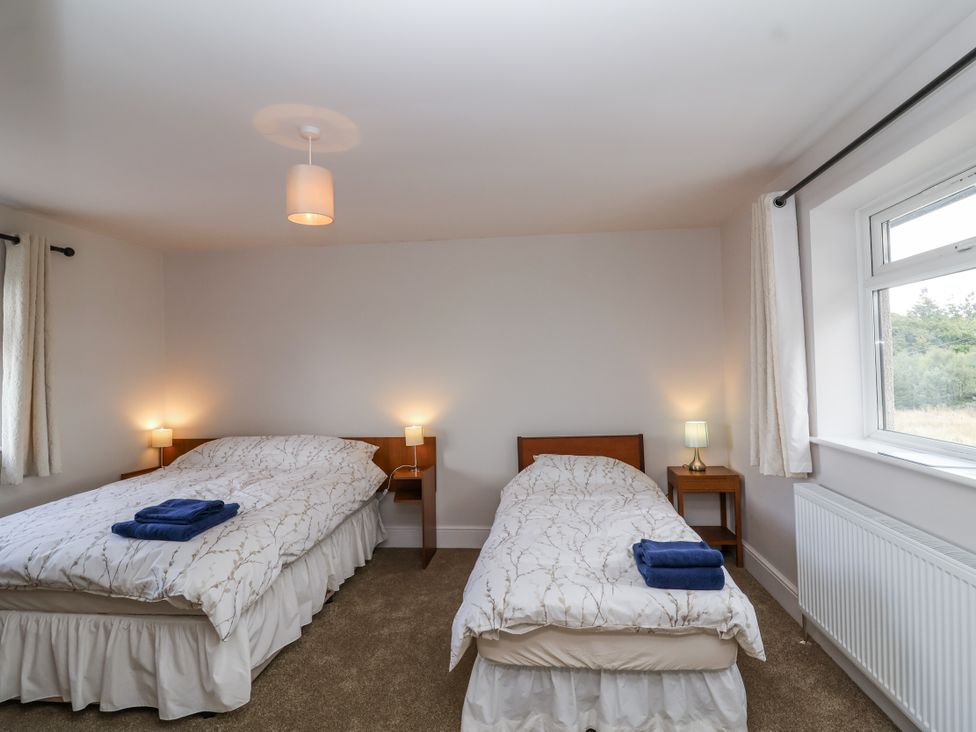 A bedroom with two beds and nightstands at The Miners Cottage in Wells