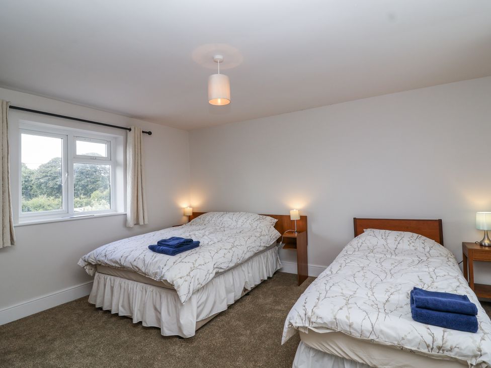 A bedroom with two beds and a window at The Miners Cottage in Wells