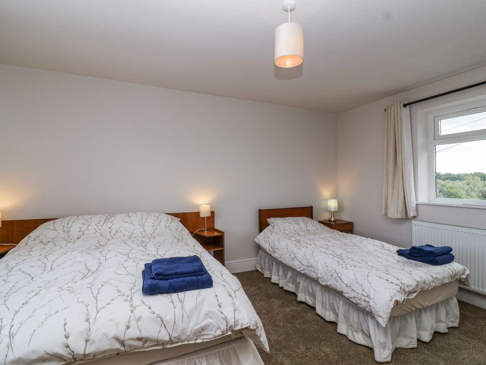 A bedroom with a double bed and a single bed at The Miners Cottage in Wells